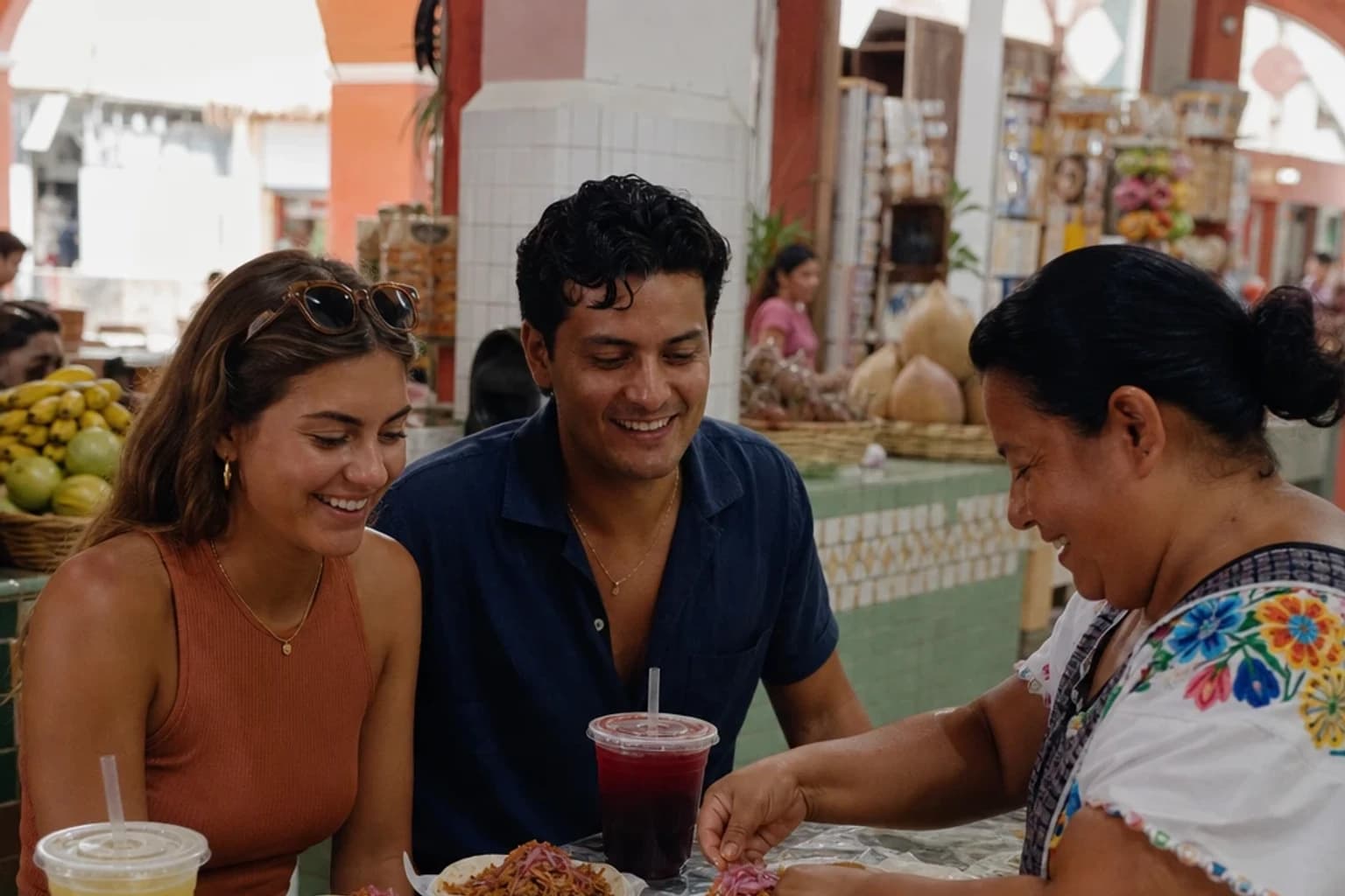 Travelers share cochinita pibil tacos and aguas frescas with a vendor in a colorful covered market