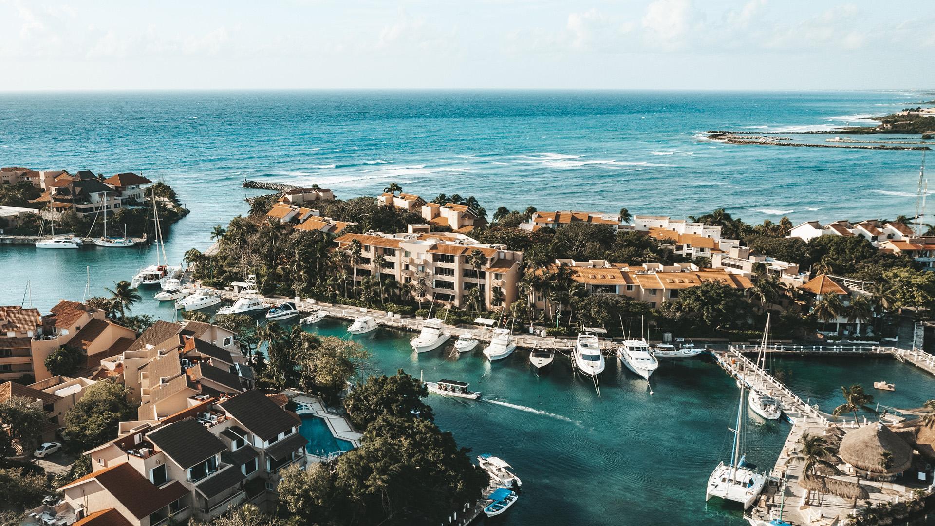 La marina de Puerto Aventuras desde el aire, con yates en los muelles y el Caribe al fondo